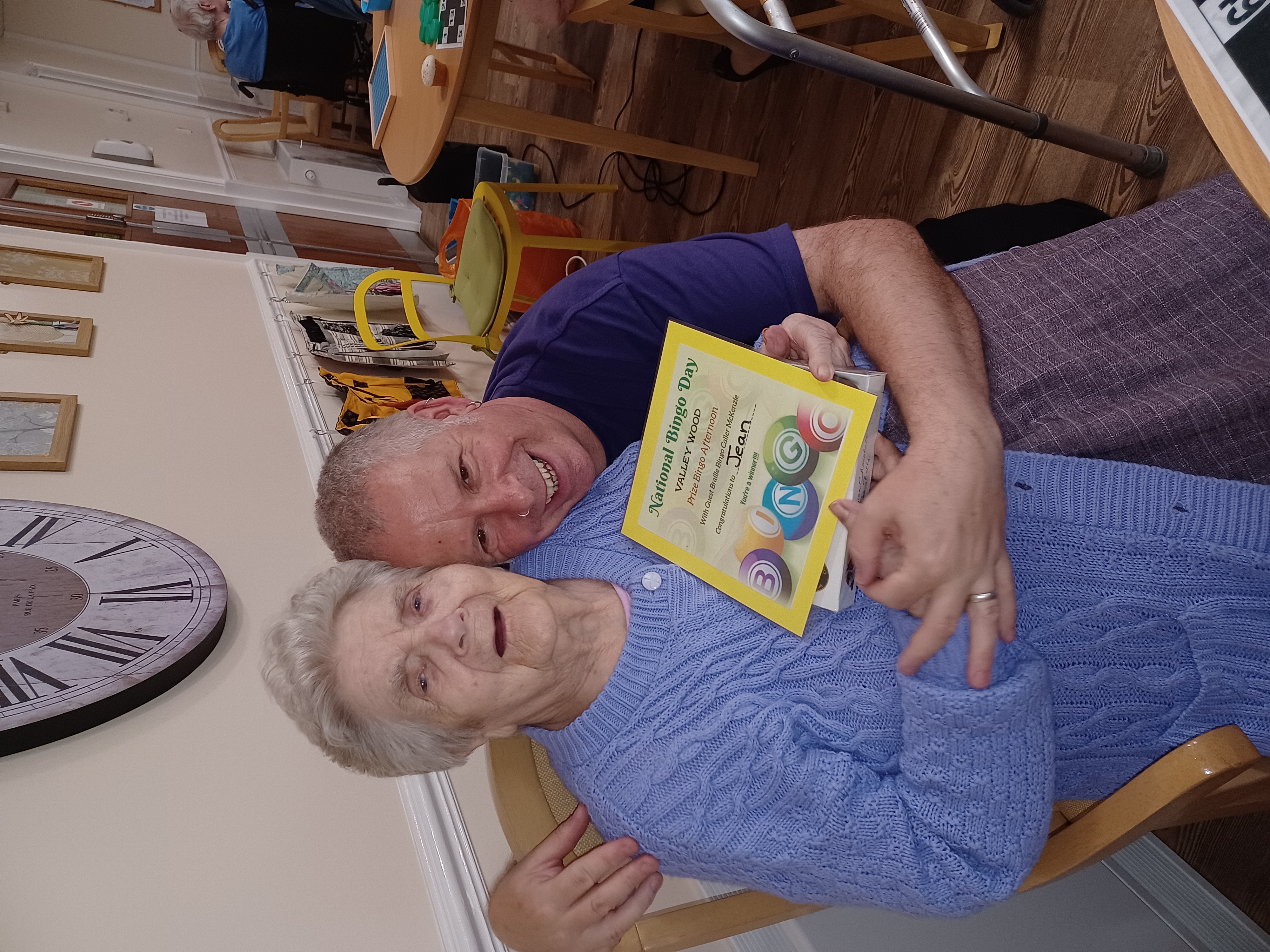 An older lady and a man showing a certificate for national bingo day